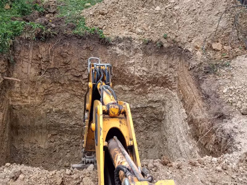 Bager JakoKAM pri hĺbení jamy pre osadenie žumpy.